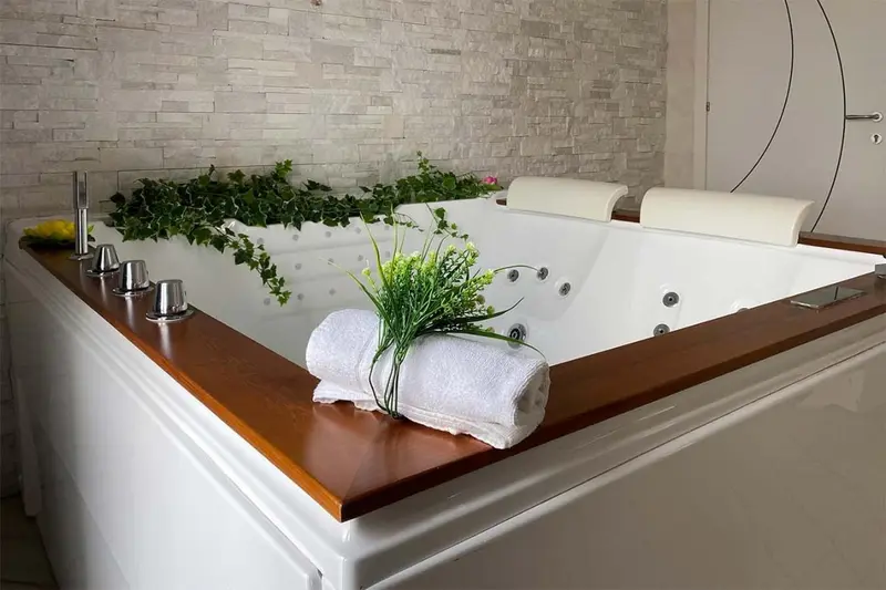 Un grand jacuzzi encastré dans une salle de bain moderne avec une décoration florale.