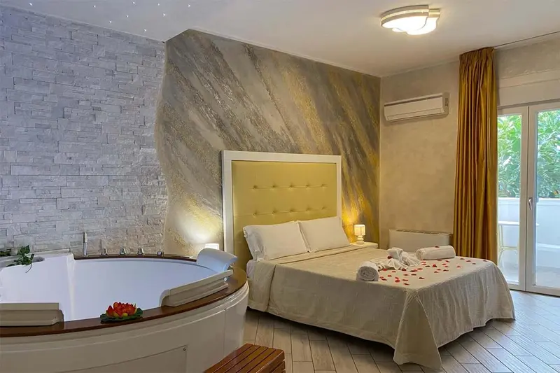 Une chambre lumineuse avec un grand lit et un jacuzzi.
