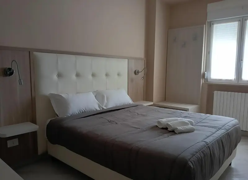 Une chambre lumineuse avec un grand lit et des tables de chevet.
