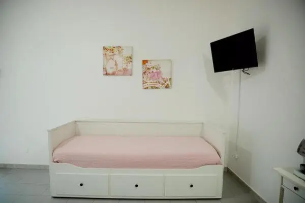 Une banquette blanche est adossée à un mur décoré de tableaux.