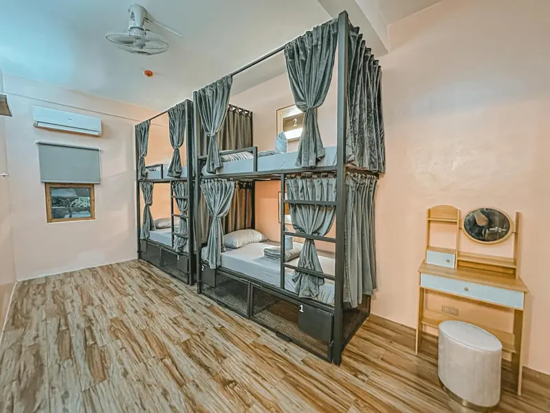 Une chambre avec des lits superposés et un coin coiffeuse.