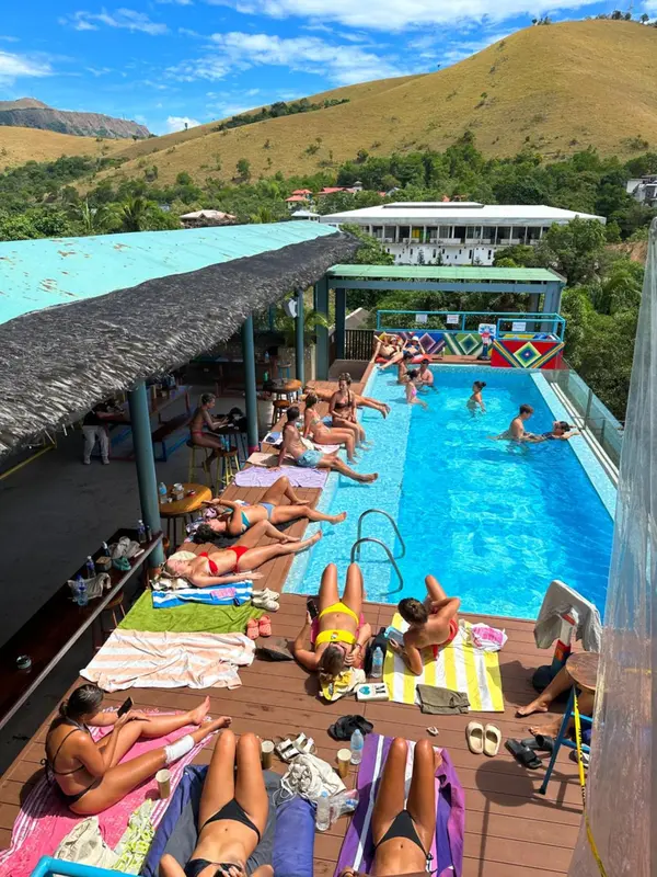 Terrasse avec piscine et chaises longues ensoleillées.