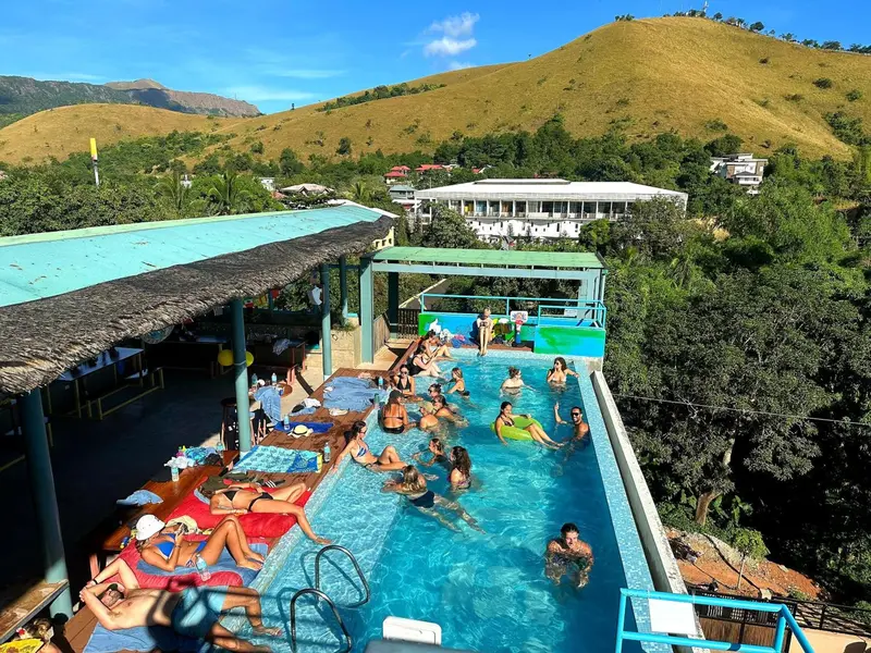 Baignade dans une piscine avec vue sur une colline verdoyante.
