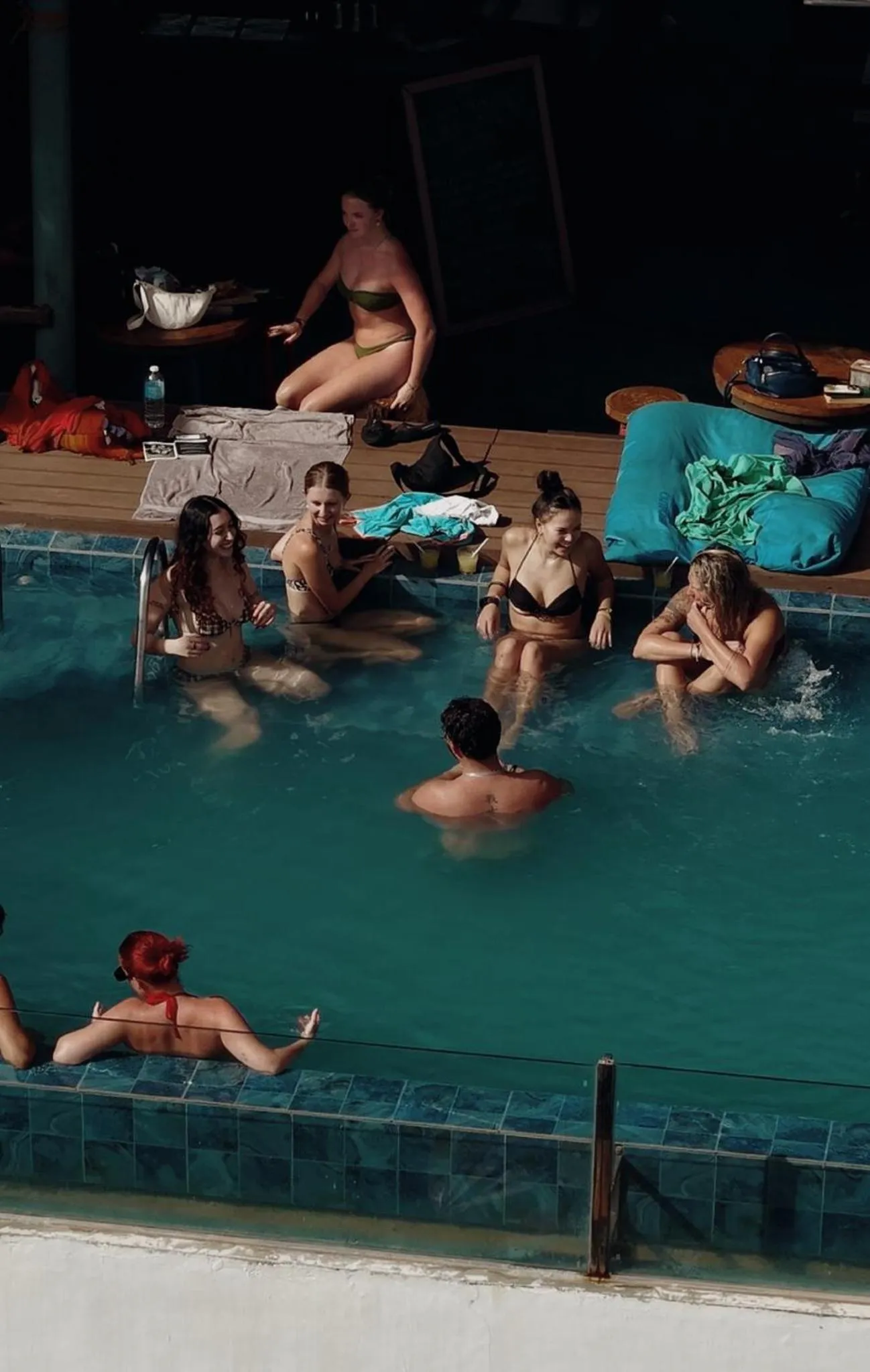 Des personnes se détendent au bord d'une piscine ensoleillée.