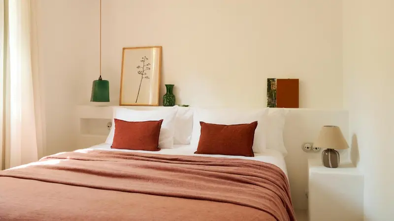 Un lit avec des oreillers et une couverture dans une chambre lumineuse.