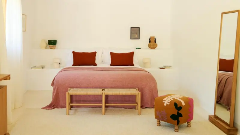 Une chambre lumineuse avec un grand lit et une décoration minimaliste.