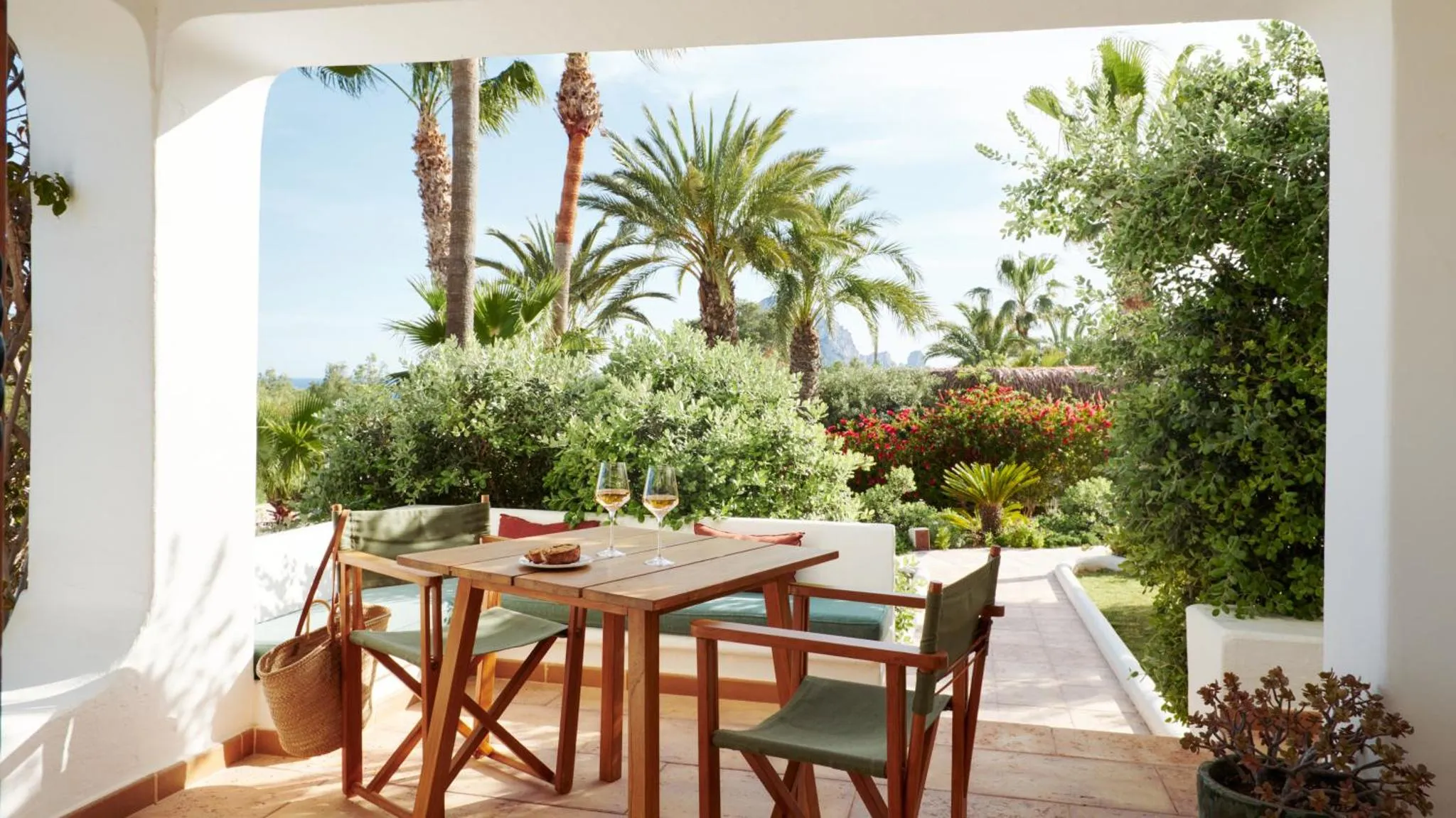 Une table et des chaises en bois invitent à la détente sur une terrasse ombragée.