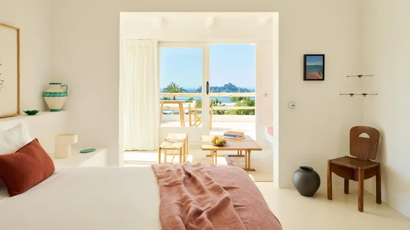 Une chambre lumineuse s'ouvre sur une terrasse avec vue sur la mer.