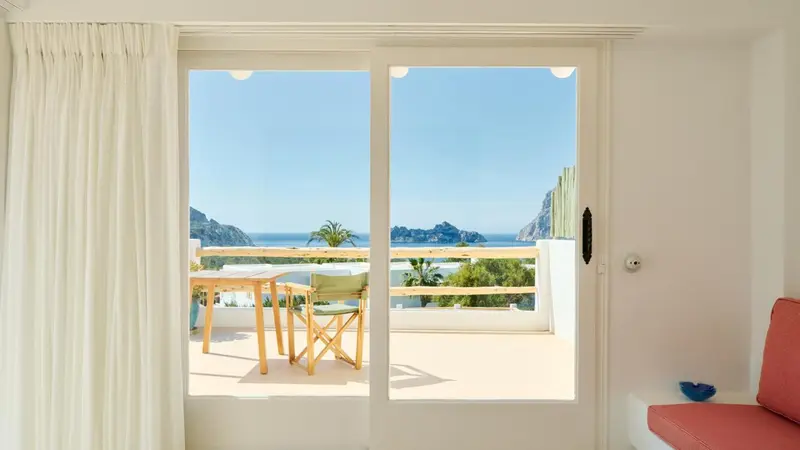 Une terrasse ensoleillée offre une vue sur la mer et les collines environnantes.