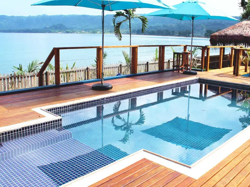 Terrasse en bois avec piscine et vue sur la mer.