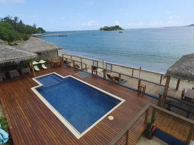 Terrasse en bois avec piscine et vue sur la mer.