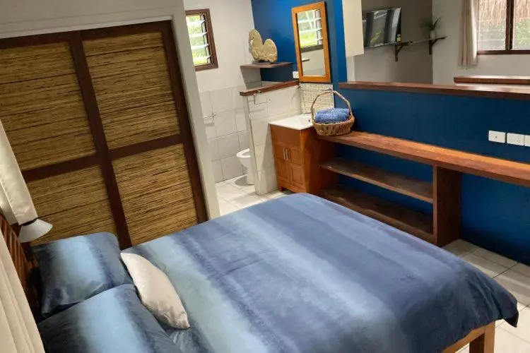 Une chambre avec un lit et un coin lavabo.