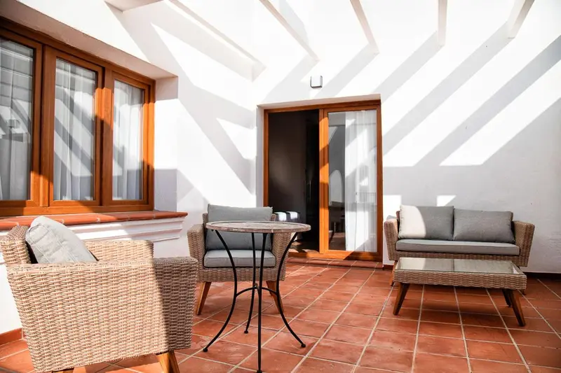 Terrasse avec mobilier en rotin et table basse.