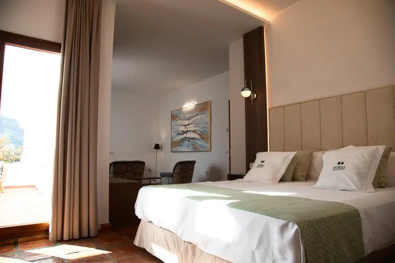Une chambre lumineuse avec un grand lit et un accès à une terrasse.
