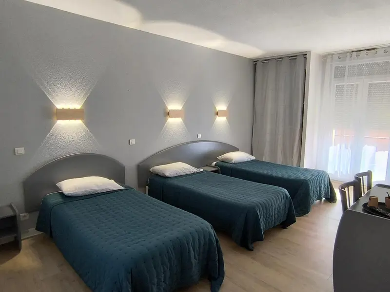 Une chambre avec deux lits simples et une fenêtre.