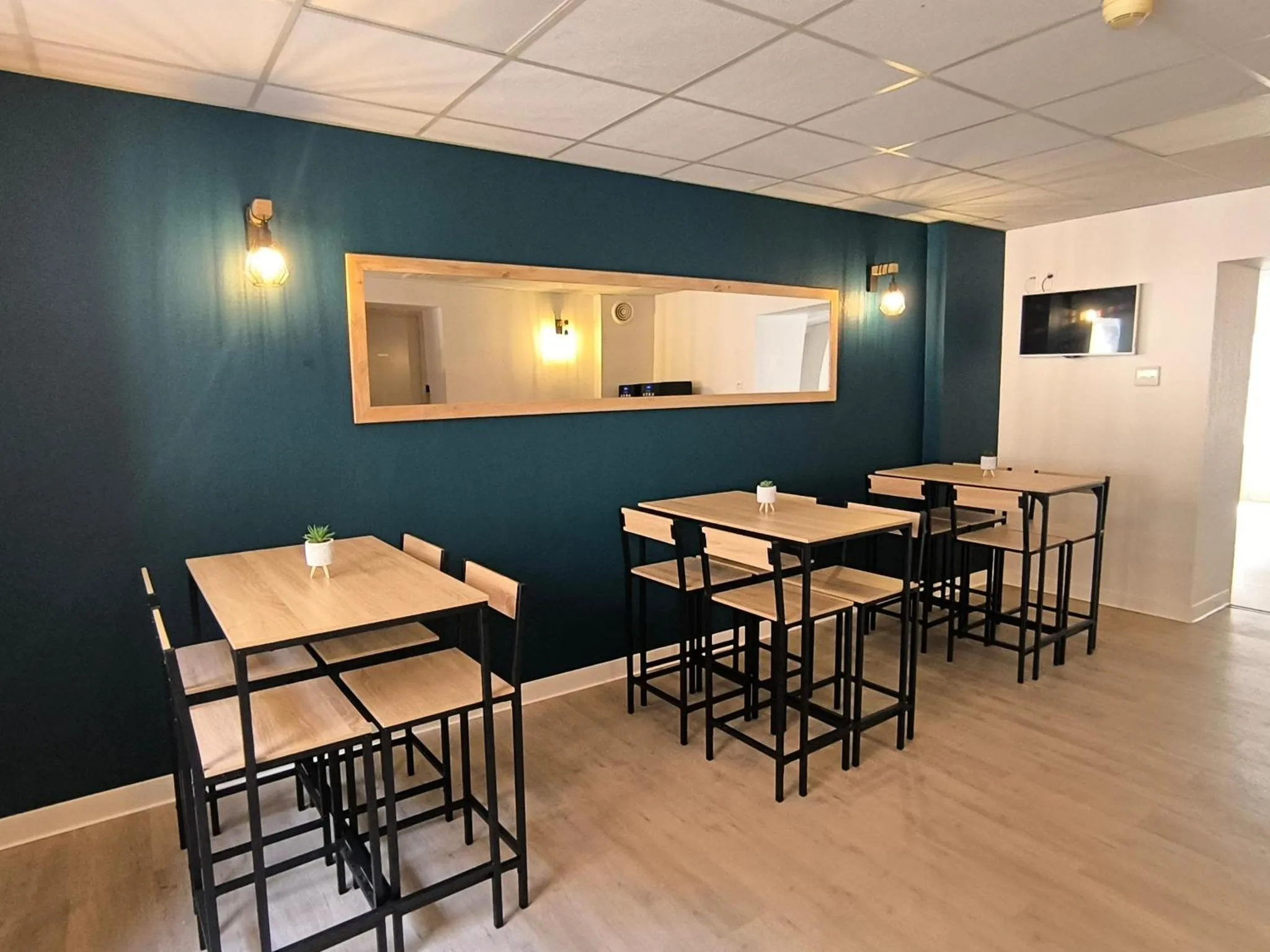Une salle lumineuse avec des tables et des chaises en bois.