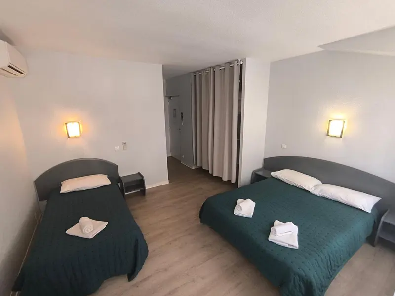 Une chambre avec deux lits simples et une décoration sobre.