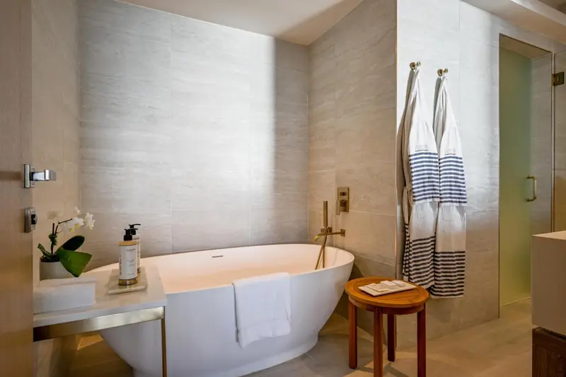 Une baignoire blanche se trouve dans une salle de bain carrelée.