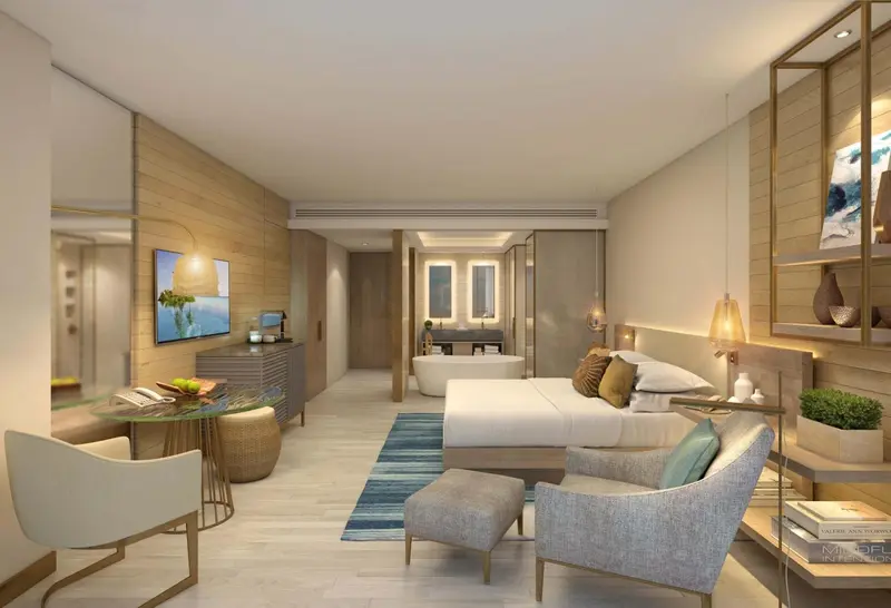 Chambre lumineuse avec un lit king-size et un espace salon.