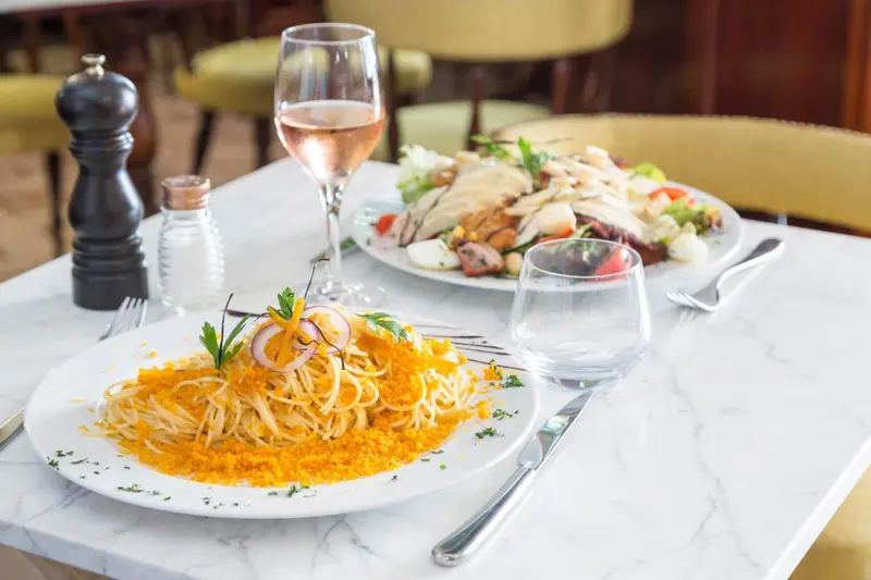 Une table est dressée avec des plats colorés et des couverts.