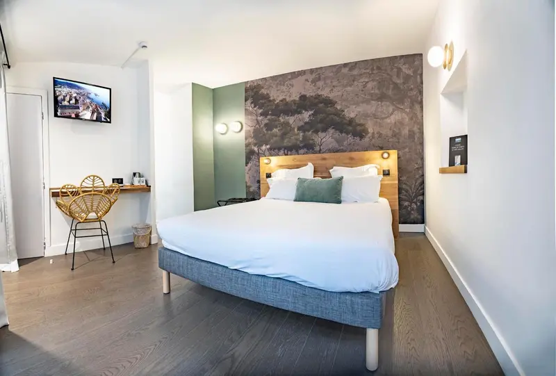 Une chambre lumineuse avec un grand lit et un bureau.