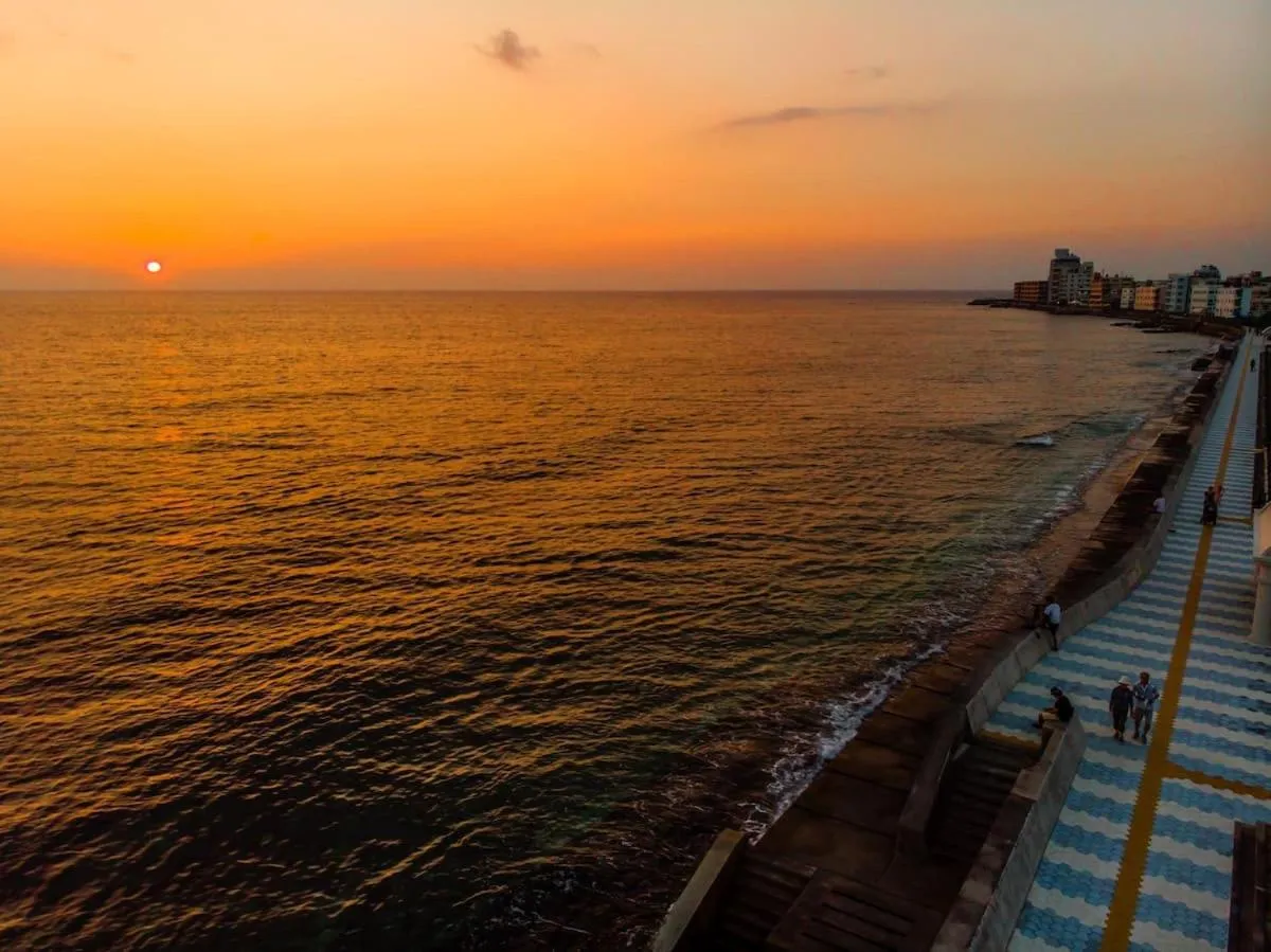 Coucher de soleil sur la mer avec une promenade en bord de mer.