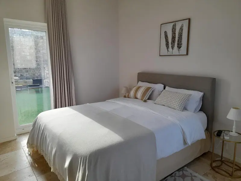 Une chambre lumineuse avec un grand lit et une vue sur l'extérieur.