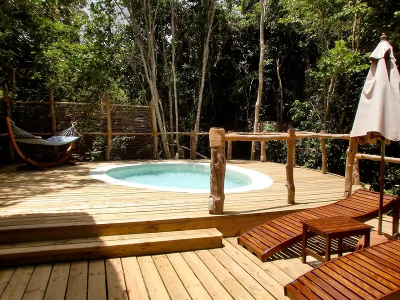 Terrasse en bois avec jacuzzi et mobilier de détente.