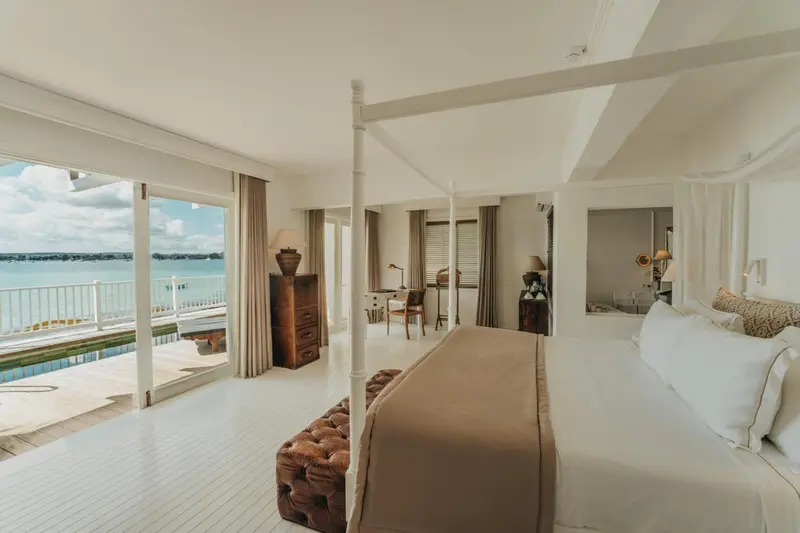 Une chambre lumineuse avec un grand lit et une vue sur la mer.