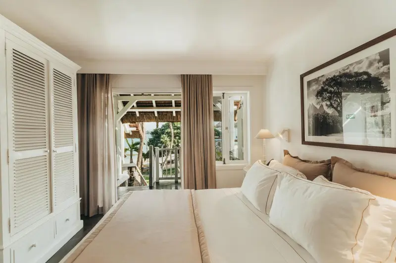 Une chambre lumineuse avec un grand lit et un accès à une terrasse.