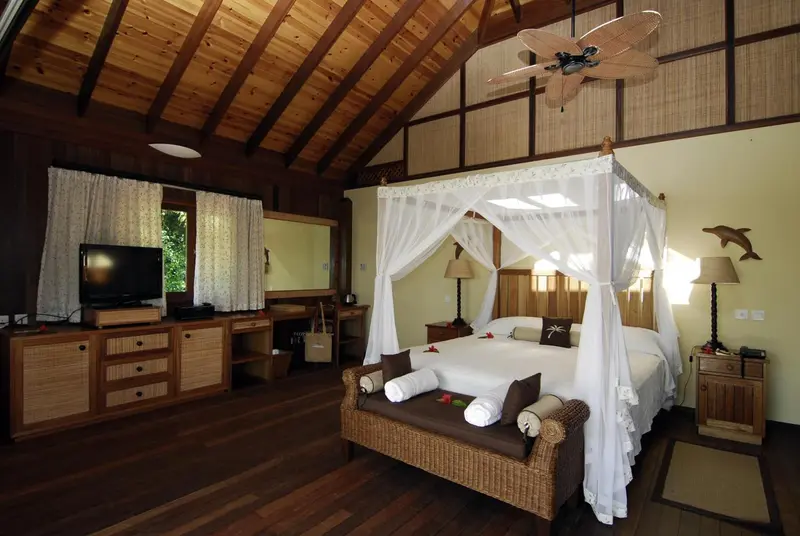 Une chambre spacieuse avec un lit à baldaquin et un coin salon.