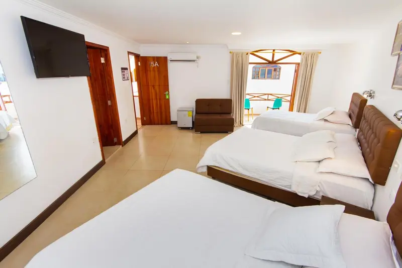 Une chambre lumineuse avec deux lits simples et un canape.