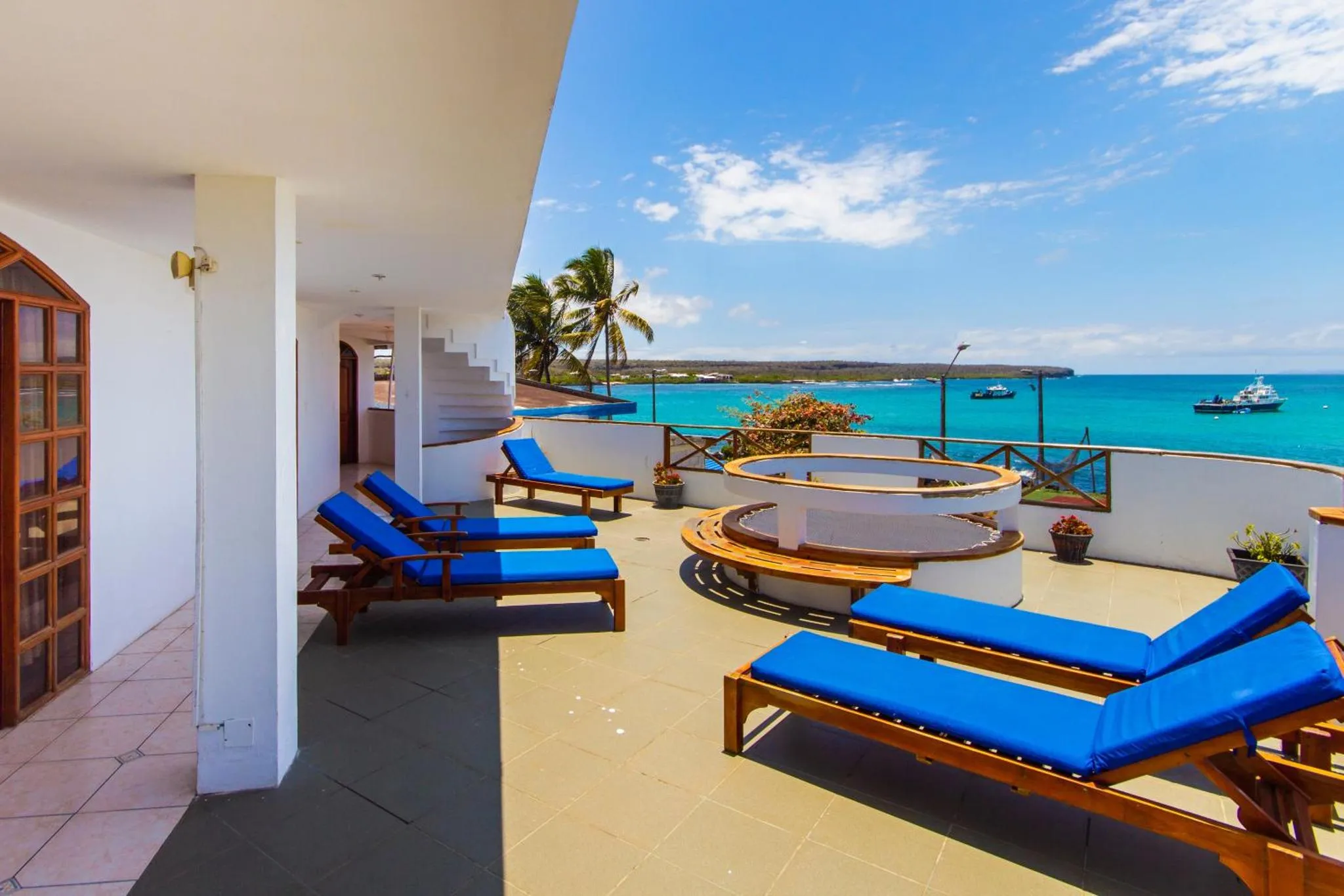 Terrasse avec chaises longues et vue sur la mer.