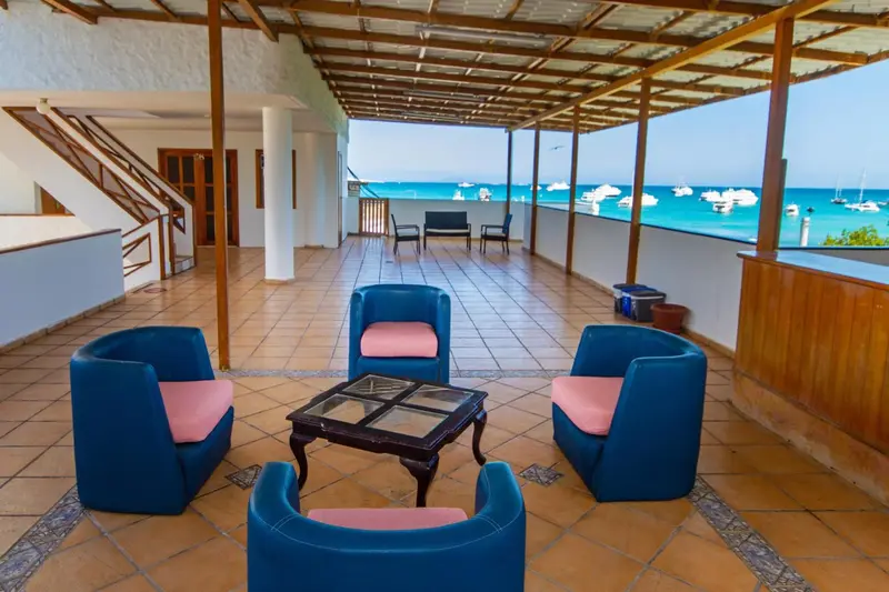 Espace de détente extérieur avec mobilier et vue sur la mer.