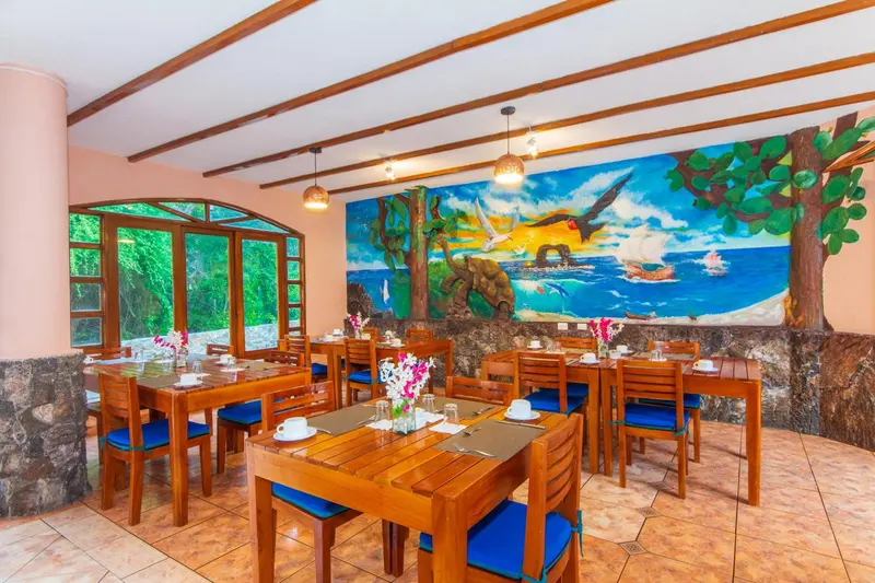 Une salle lumineuse avec des tables dressées pour le repas.
