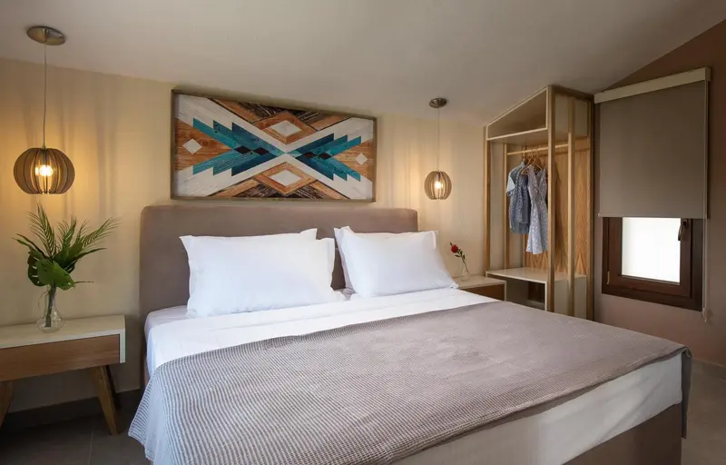 Une chambre lumineuse avec un grand lit et une décoration murale.