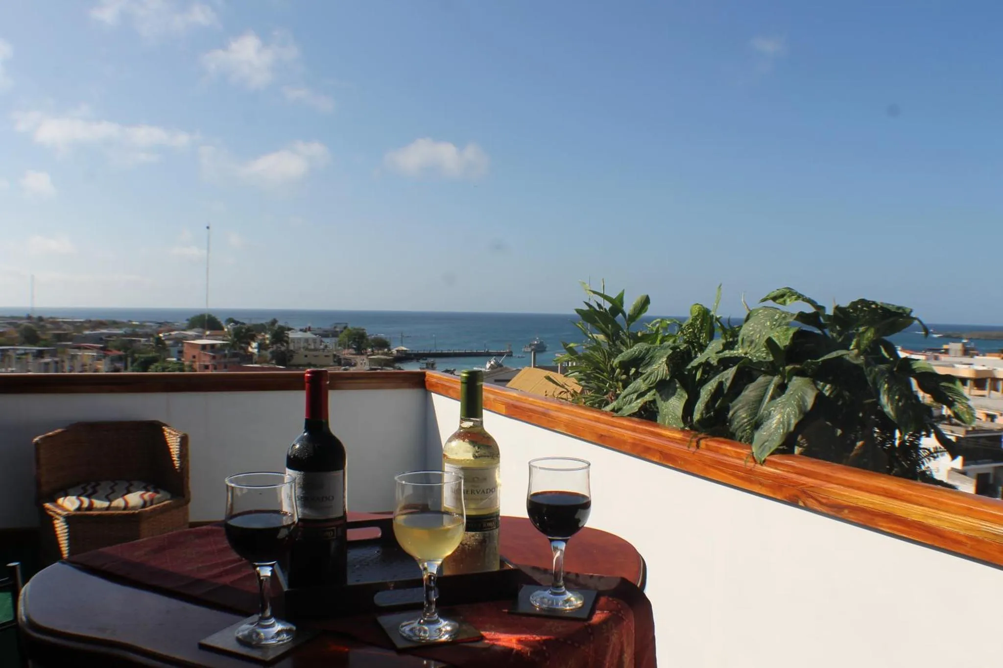 Une table avec des bouteilles et des verres de vin sur une terrasse ensoleillée.