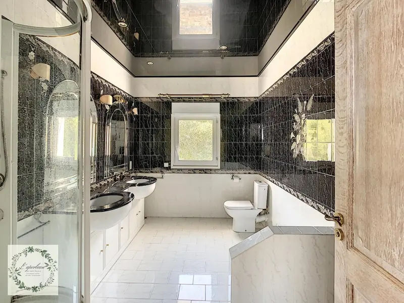 Salle de bain moderne avec carrelage noir et blanc et deux vasques.