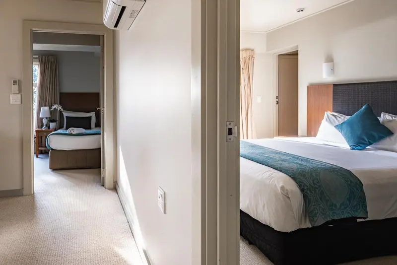 Une chambre lumineuse avec deux lits et une décoration sobre.