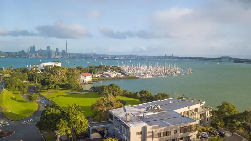 Vue aérienne d'une marina et d'une ville côtière ensoleillée.