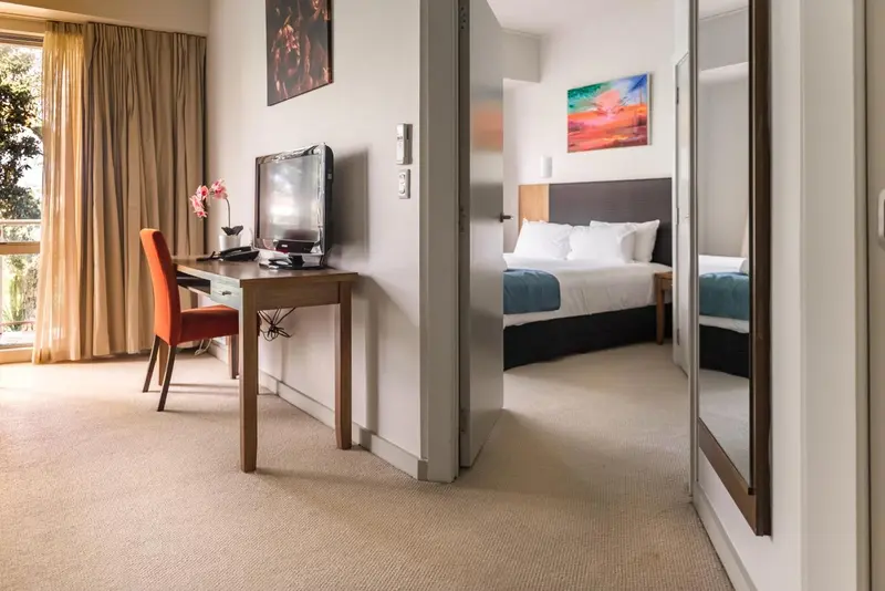 Une chambre lumineuse avec un bureau et un lit.