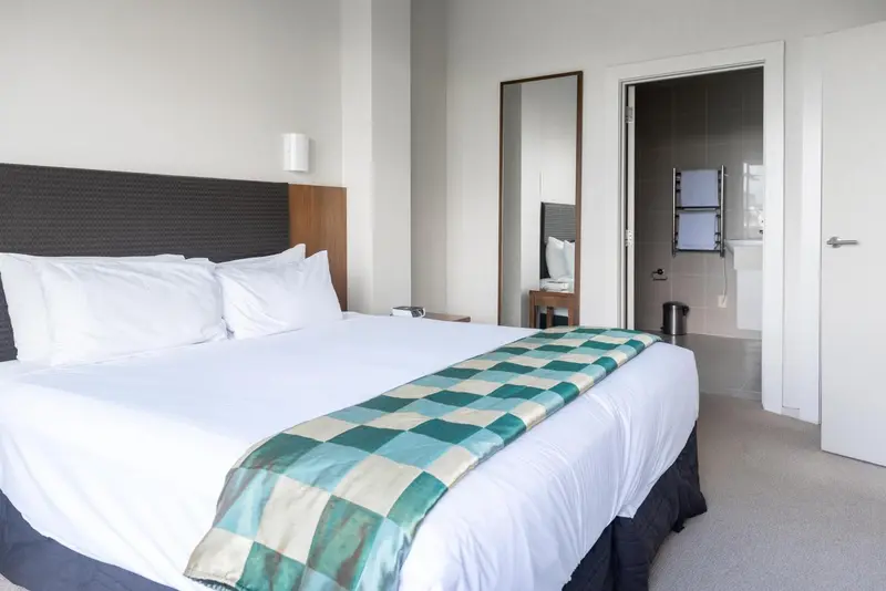 Une chambre d'hôtel moderne avec un grand lit recouvert d'une courtepointe.