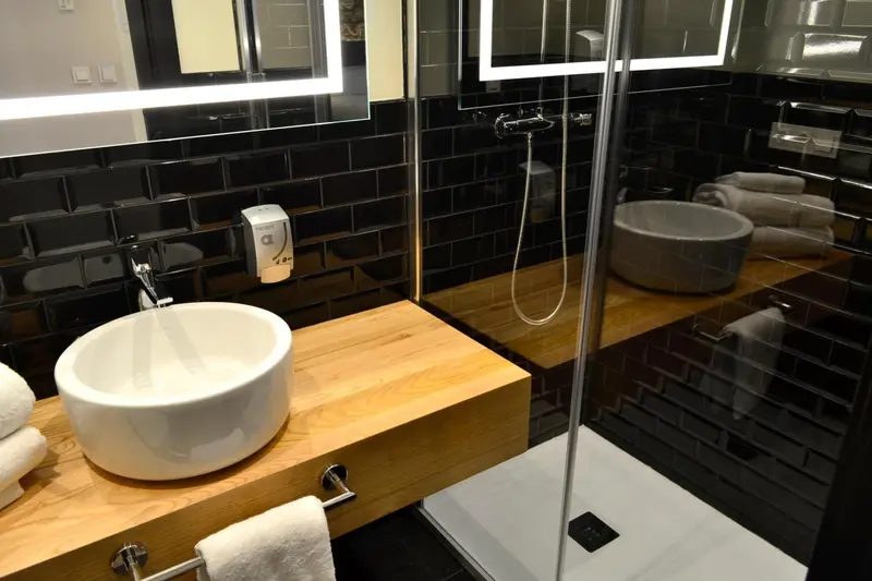 Une salle de bain moderne avec une douche à l'italienne et des lavabos blancs.