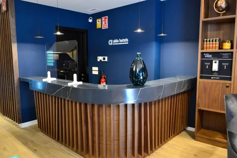 Un comptoir d'accueil moderne avec un mur en bois et des luminaires suspendus.