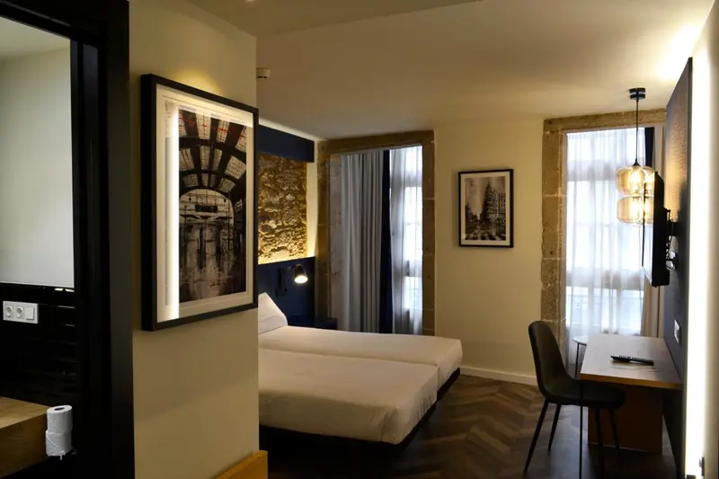 Une chambre lumineuse avec un lit double et un bureau.