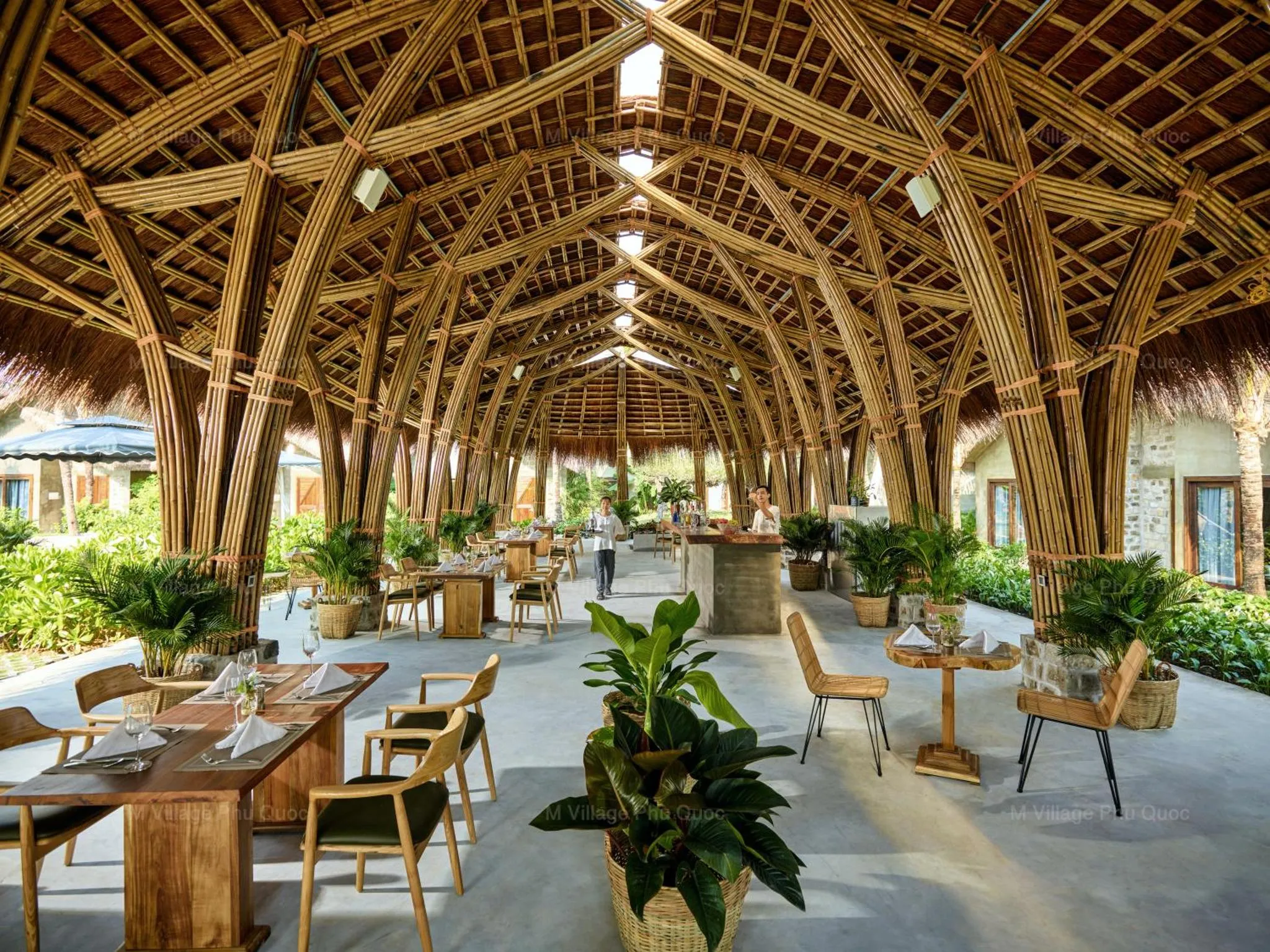 Une salle à manger ouverte avec des tables et des chaises en bois.