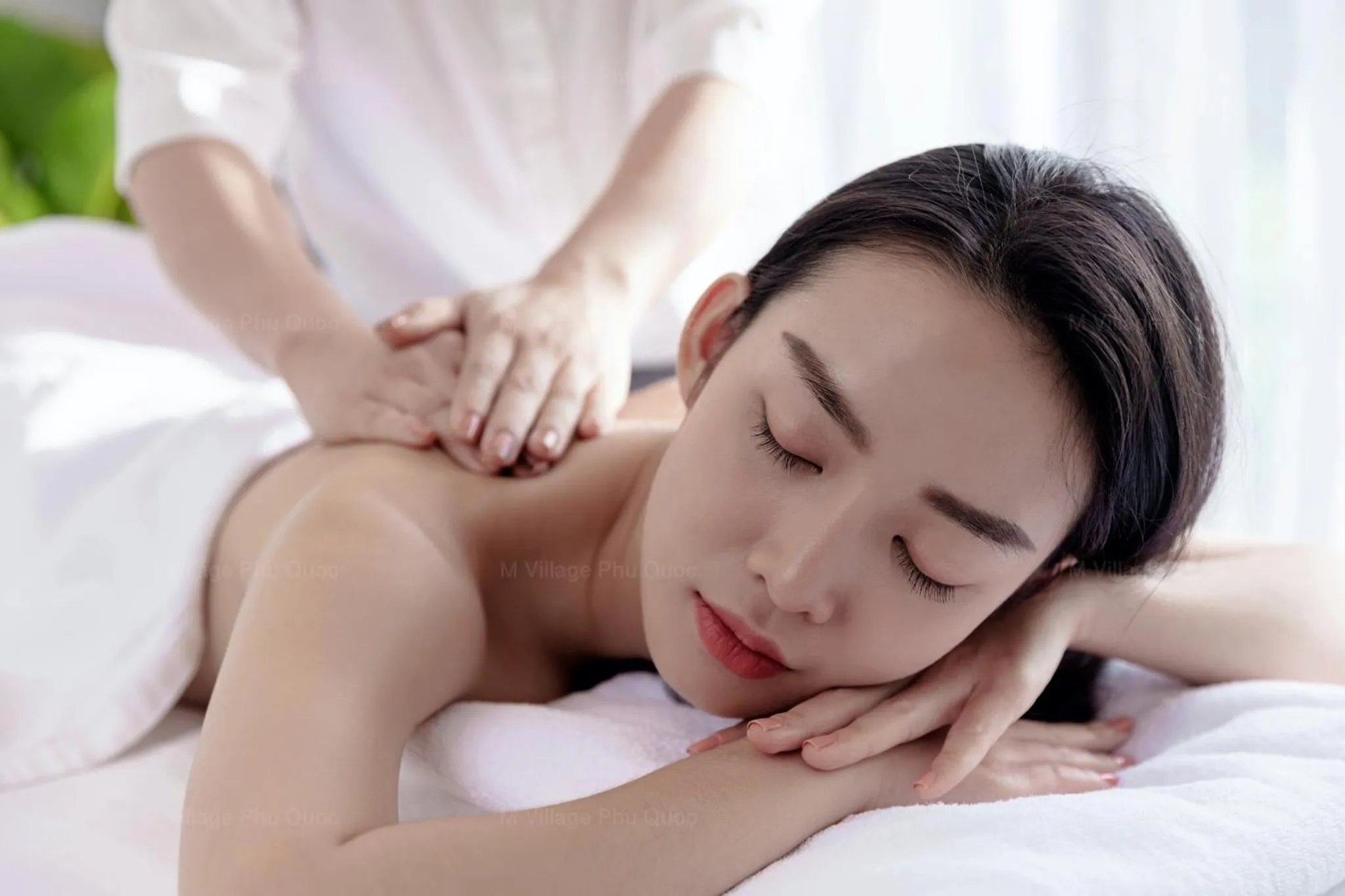 Une femme allongée reçoit un massage relaxant.