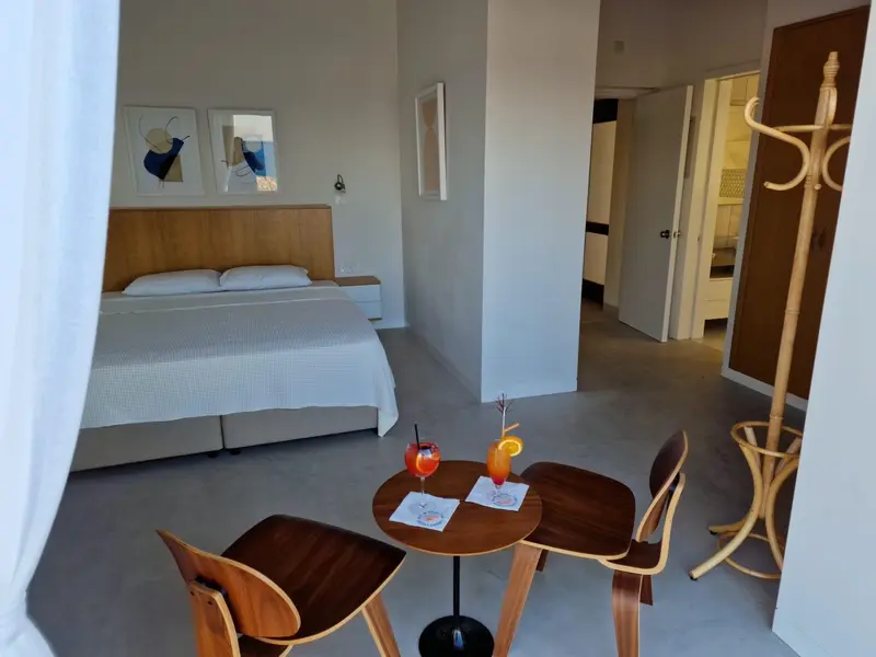 Une chambre lumineuse avec un lit et une petite table avec des boissons.
