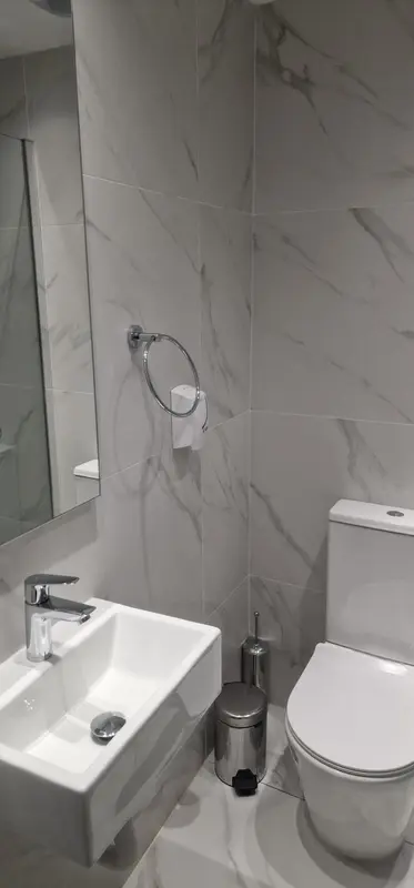 Une salle de bain moderne avec des carreaux blancs et un lavabo.