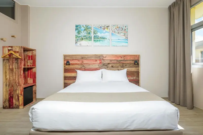 Une chambre lumineuse avec un grand lit et une décoration murale en bois.